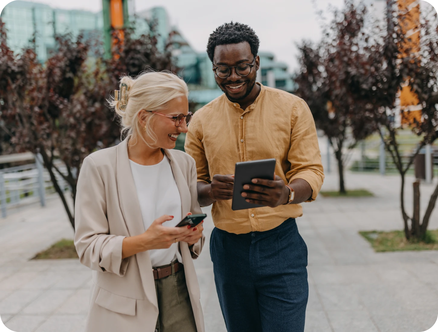 Business casual duo with smartphones and tablet